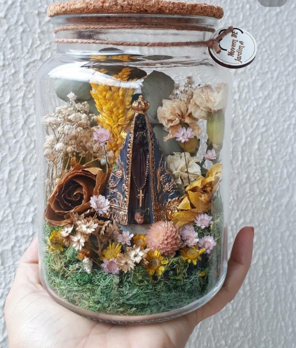Jardim com flores naturais desidratadas e preservadas. Decorada com imagem sacra. Podemos fazer com Nossa Senhora de Fátima, Aparecida, Perpetuo Socorro, Jesus Misericordioso e Sagrada Família. Cada planta tem sua estrutura. No entanto o jardim pode variar um pouco no designer interior. 